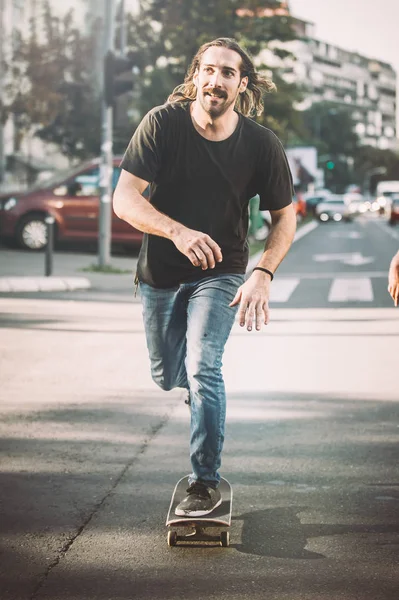 Şehir yolda araba önünde Pro kaykay binici