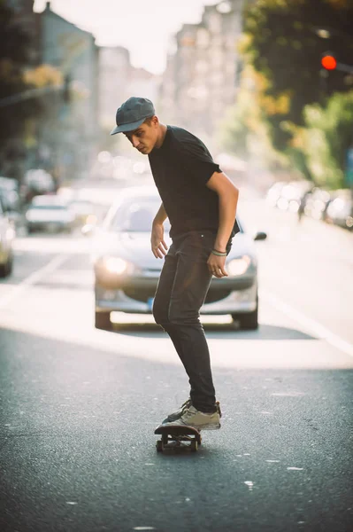 Skateboard-Profi vor Auto auf der Stadtstraße — Stockfoto