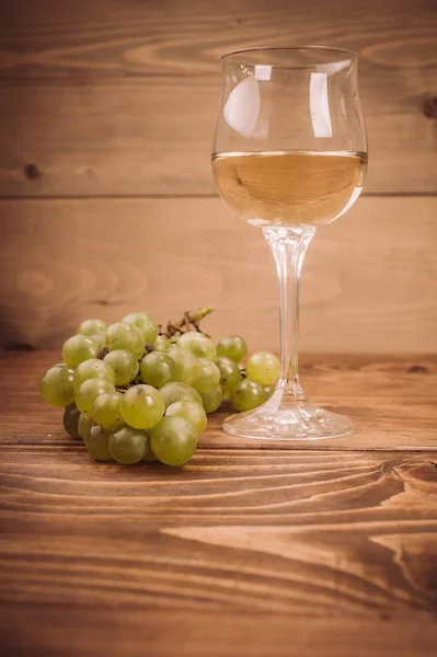 Copa de vino blanco y uvas sobre mesa de madera rústica —  Fotos de Stock