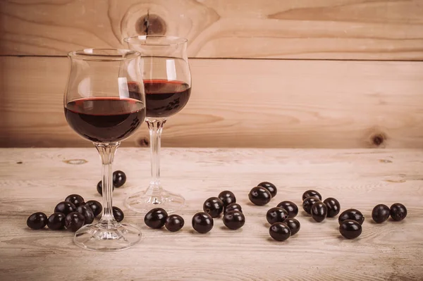 İki kadeh kırmızı şarap ve üzüm ahşap tablo