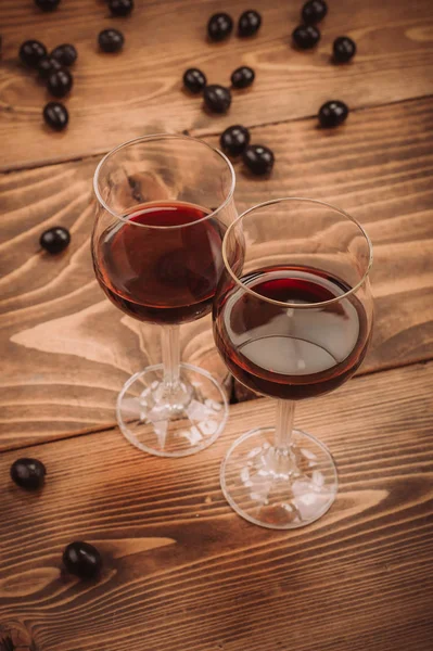 Два бокала красного вина и винограда на деревянном столе — стоковое фото