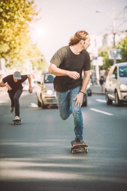 İki pro kaykay binici ride skate arabasının camından Caddesi üzerinde