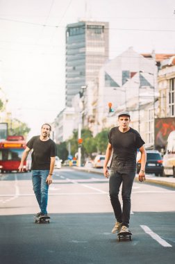 İki pro kaykay binici ride skate arabasının camından Caddesi üzerinde