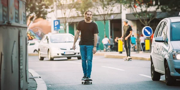 İki pro kaykay binici ride skate arabasının camından Caddesi üzerinde