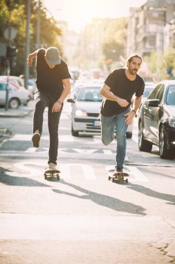 İki pro kaykay binici ride skate arabasının camından Caddesi üzerinde