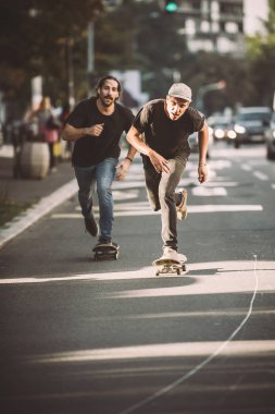 İki pro kaykay binici ride skate arabasının camından Caddesi üzerinde