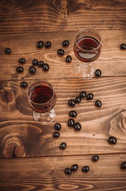 İki kadeh kırmızı şarap ve üzüm ahşap tablo