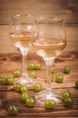 İki kadeh beyaz şarap ve üzüm ahşap tablo