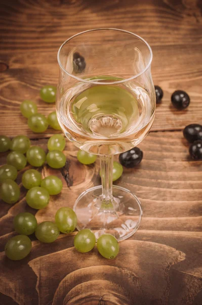 Kadeh beyaz şarap ve üzüm rustik ahşap masa üzerinde