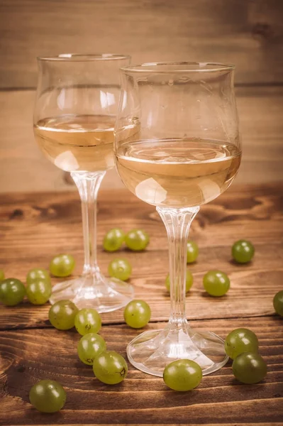 İki kadeh beyaz şarap ve üzüm ahşap tablo