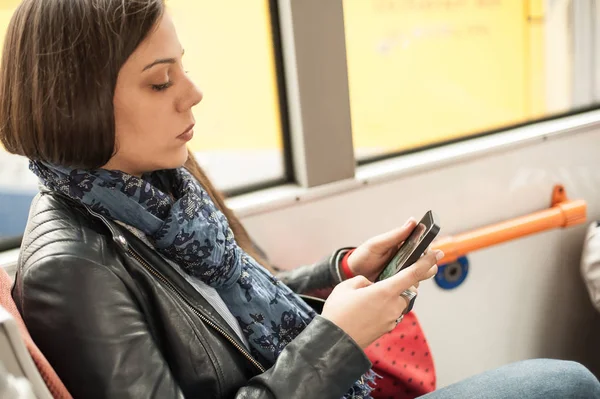Młoda dziewczyna wykorzystuje telefon komórkowy w autobusie miejskim — Zdjęcie stockowe