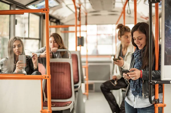 Young girl uses a mobile phone in the city bus