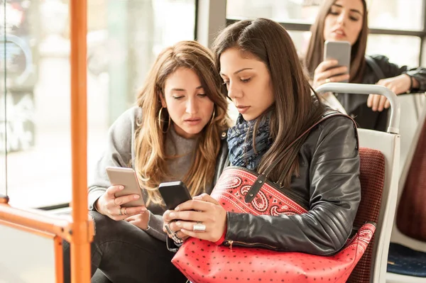 Genç kız bir cep telefonu şehir otobüs kullanır. — Stok fotoğraf