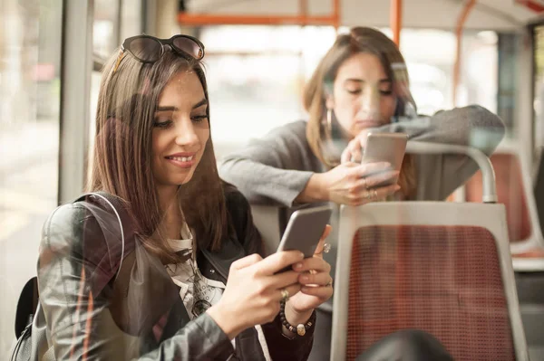 Genç kız bir cep telefonu şehir otobüs kullanır. — Stok fotoğraf