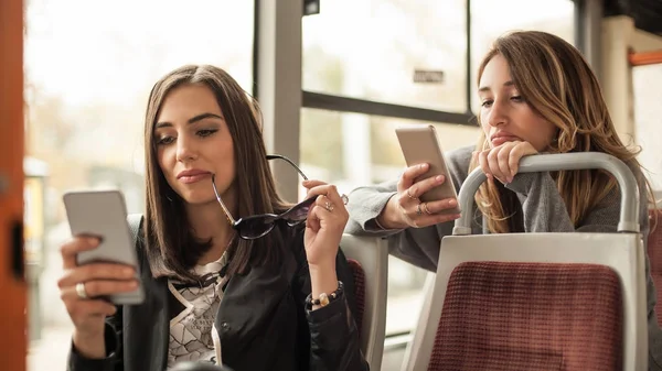 Genç kız bir cep telefonu şehir otobüs kullanır. — Stok fotoğraf