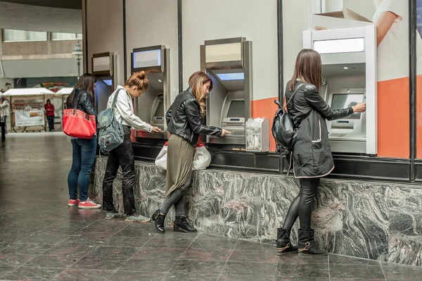 Quatro amigas retirando dinheiro do cartão de crédito no ATM — Fotografia de Stock