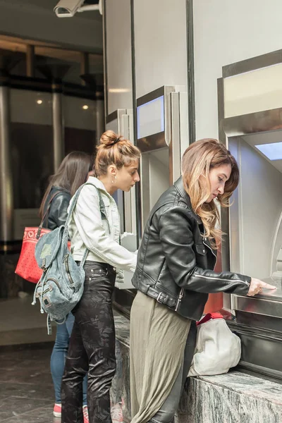 Drie vriendinnen opnemen van geld van credit card bij Atm — Stockfoto