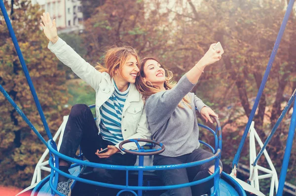 遊園地で楽しみながら selfie を取っている 2 つの女の子 — ストック写真
