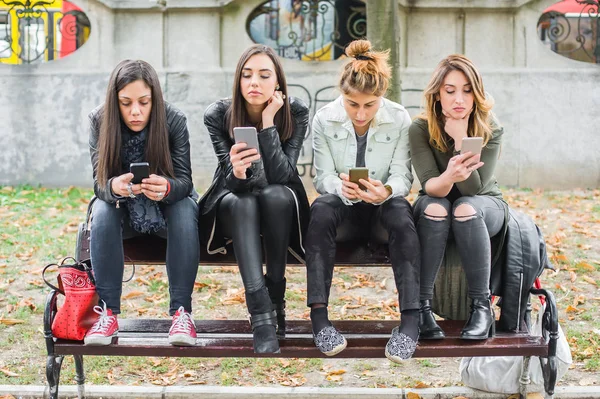 Csoport a lányok használata cellphones-padon — Stock Fotó