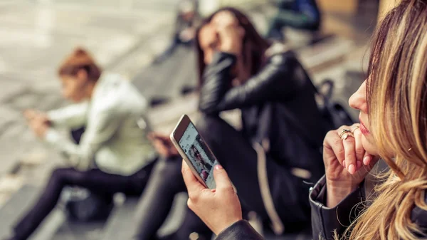 Mädchengruppe sitzt mit Smartphone auf der Treppe der Stadt — Stockfoto