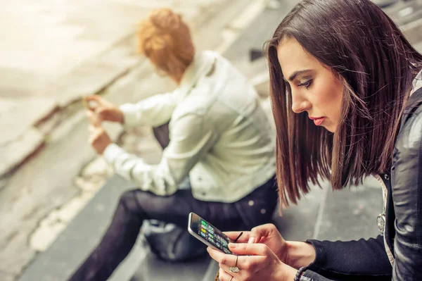 Mädchengruppe sitzt mit Smartphone auf der Treppe der Stadt — Stockfoto