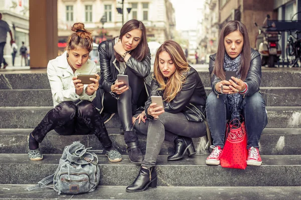 Groupe de filles assis sur les escaliers de la ville avec smartphone — Photo