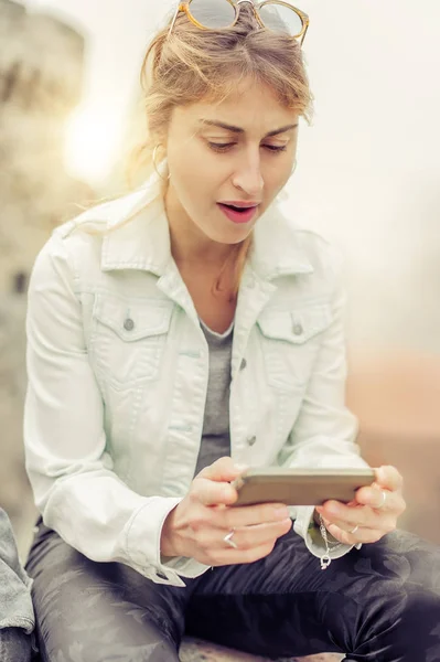 Kobieta siedzi na ulicy, pisanie wiadomości, rozmowy na smartp — Zdjęcie stockowe