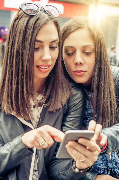 Zwei Freundinnen glücklich beim Betrachten von sozialen Medien im Internet in smartph — Stockfoto