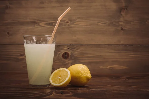 Copo de suco de limão fresco com metade de limão fatiado — Fotografia de Stock