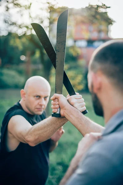 Martial arts instructor demonstrates machete fighting. Long knif