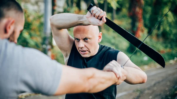 Un instructeur d'arts martiaux démontre un combat à la machette. Couteau long — Photo