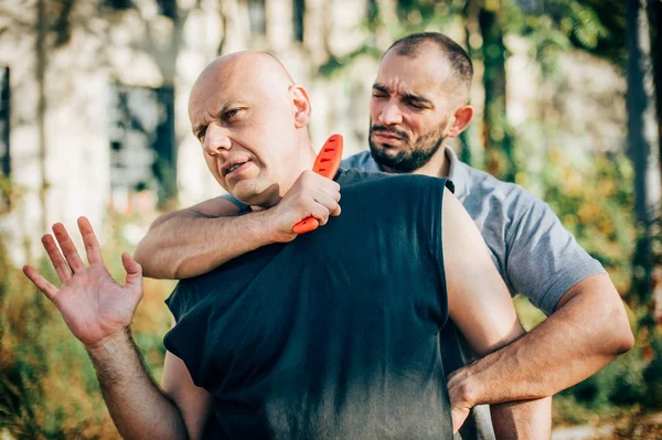 Amenaza de cuchillo. Instructor Kapap demuestra cuchillo de defensa personal t — Foto de Stock