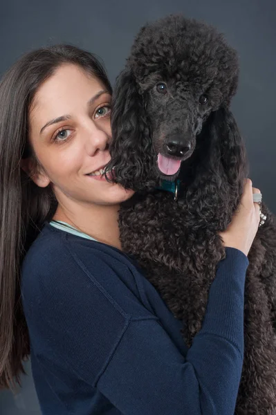 Portrait d'une belle jeune femme embrassant son beau chien — Photo