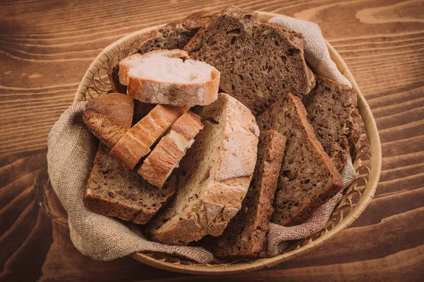 Varios panes y panecillos horneados en mesa de madera rústica — Foto de Stock