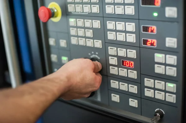 Trabajador de fábrica ajusta el panel de control de la máquina de la industria —  Fotos de Stock