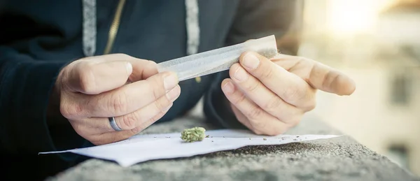 Homem preparando charuto haxixe rolando cigarro de maconha para fumar — Fotografia de Stock