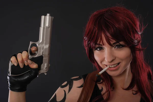 Piękne redhead kobieta z pistoletu na ciemnym tle — Zdjęcie stockowe