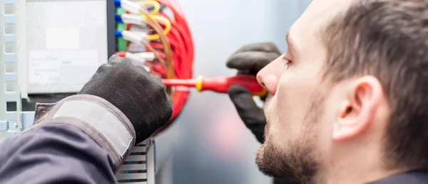 Vértes villanyszerelő mérnök dolgozik a vezetékek elektromos kábel — Stock Fotó