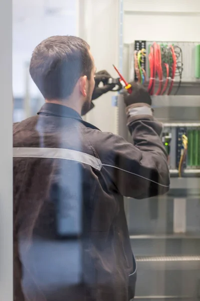 Strojní elektrikář testuje elektrické instalace na relé pro — Stock fotografie