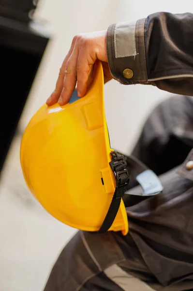 Arbeiter hält gelben Schutzhelm in der Hand — Stockfoto