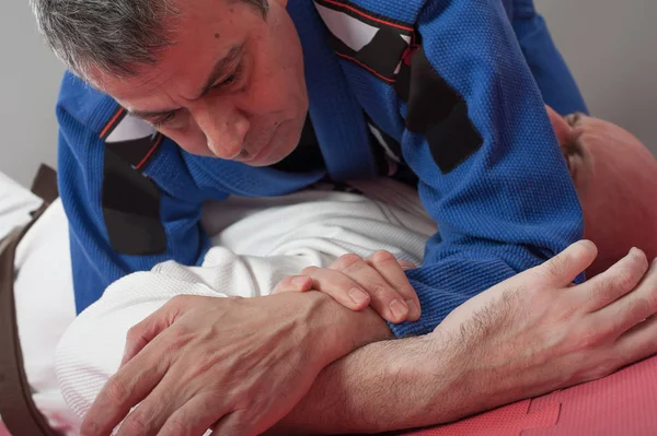 Instructor de jiu jitsu brasileño demuestra brazo de combate terrestre —  Fotos de Stock