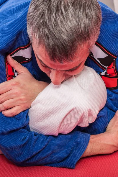 Instructor de jiu jitsu brasileño demuestra brazo de combate terrestre — Foto de Stock