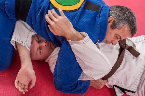 Instructor de jiu jitsu brasileño demuestra brazo de combate terrestre — Foto de Stock