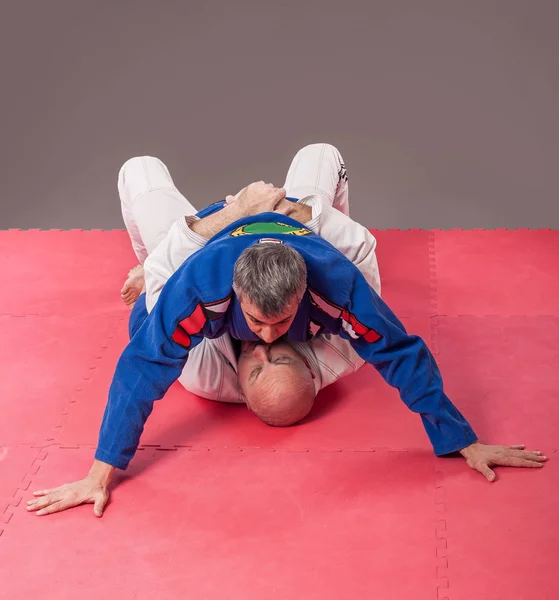 Jiu-jitsu Brazil instruktur dalam kimono tradisional menunjukkan tanah — Stok Foto