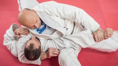 BJJ Brazilian jiu-jitsu training demonstration in traditional ki clipart