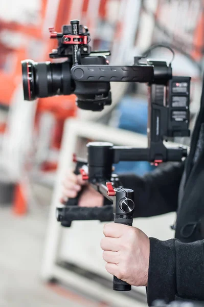 Videographer using stadicam, making video of machine at factory — Stock Photo, Image