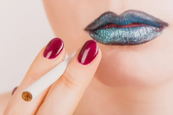 Gros plan du visage de la femme avec la cigarette et le maquillage tinsel — Photo