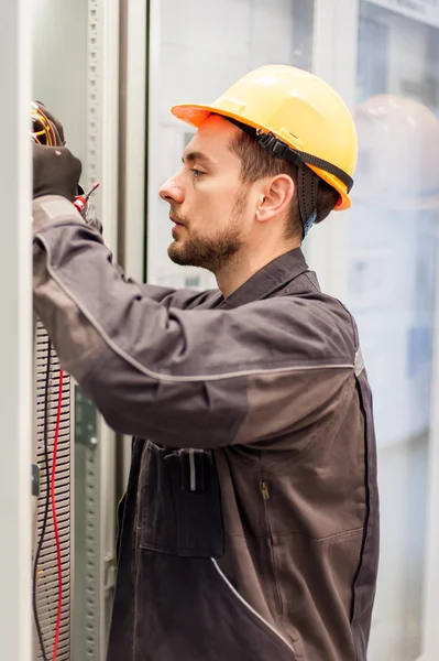 Strojní elektrikář testuje elektrické instalace na relé pro — Stock fotografie