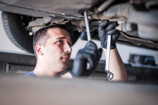 Reparador mecánico de automóviles que comprueba la condición bajo coche en el vehículo l —  Fotos de Stock