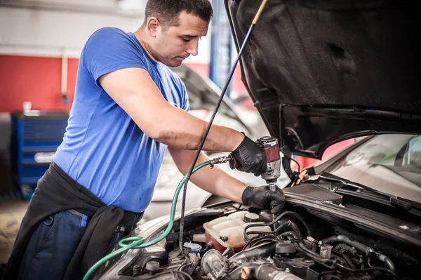 Auto mecánico reparador cambiando bujías en el coche —  Fotos de Stock